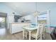 Bright dining area with glass table, seating for four, chandelier, with view into kitchen at 6800 Placida Rd # 262, Englewood, FL 34224