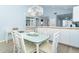 Bright dining area with glass table, seating for four, chandelier, with view into kitchen at 6800 Placida Rd # 262, Englewood, FL 34224