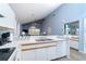 Bright kitchen featuring white cabinets, light blue walls, and an open layout to the living area at 6800 Placida Rd # 262, Englewood, FL 34224