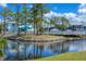 Scenic pond view with a foot bridge, mature trees, and lush landscaping at 6800 Placida Rd # 262, Englewood, FL 34224