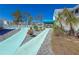 Relaxing poolside lounge area with chairs, lush landscaping, and a covered patio at 6800 Placida Rd # 262, Englewood, FL 34224