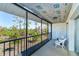 Relaxing screened porch overlooking trees with white wicker furniture and overhead shade at 6800 Placida Rd # 262, Englewood, FL 34224