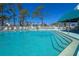 Inviting in-ground pool with clear blue water, surrounded by lounging chairs and umbrellas at 6800 Placida Rd # 262, Englewood, FL 34224