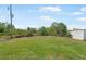 Expansive green backyard with a shed and lush vegetation at 7089 Benson St, Englewood, FL 34224