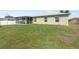 A large, grassy backyard featuring a view of the screened-in patio at 7089 Benson St, Englewood, FL 34224