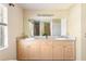 Spacious bathroom featuring double sinks, a large mirror, and modern lighting fixtures at 7089 Benson St, Englewood, FL 34224