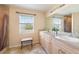 Bright bathroom featuring a double vanity, tile floors, shower, and a window for natural light at 7089 Benson St, Englewood, FL 34224