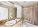 Well-lit bathroom featuring a single vanity, tile floors, a bathtub, and a shower with a curtain at 7089 Benson St, Englewood, FL 34224