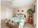Cozy bedroom showcasing tile floors, bed with tropical print bedding, and a ceiling fan at 7089 Benson St, Englewood, FL 34224