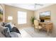 Bright bedroom features a daybed, a wooden desk, and a large window overlooking the beautiful front yard at 7089 Benson St, Englewood, FL 34224