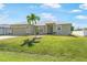 Charming single-story home with a well-manicured lawn and a palm tree in the front yard at 7089 Benson St, Englewood, FL 34224