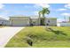 Charming single-story home featuring a well-manicured lawn and a welcoming entrance with a palm tree at 7089 Benson St, Englewood, FL 34224