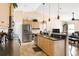 Open kitchen with stainless appliances, light wood cabinets, pendant lighting and a breakfast bar overlooking the living area at 7089 Benson St, Englewood, FL 34224