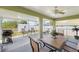 The screened-in patio features a ceiling fan, outdoor dining set, grill, and view of the backyard shed at 7089 Benson St, Englewood, FL 34224