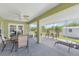 A spacious screened-in patio with an outdoor table set, grill, and access to the backyard shed at 7089 Benson St, Englewood, FL 34224