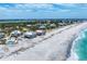 Picturesque coastal homes on a sandy beach with clear ocean waters, bordered by lush vegetation and a lake at 7554 Palm Island S Dr # 1822, Placida, FL 33946