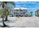 Beautiful beach house featuring balconies, stairs and a metal roof, with palm trees, surrounded by white sand at 7554 Palm Island S Dr # 1822, Placida, FL 33946