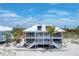Beachfront home featuring expansive balconies with white railings and steps to the beach at 7554 Palm Island S Dr # 1822, Placida, FL 33946