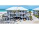 Coastal beach house with stairs to the balconies and beach featuring a pristine white exterior at 7554 Palm Island S Dr # 1822, Placida, FL 33946