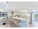 Bright open concept kitchen with white cabinetry, a breakfast bar and views of the laundry room and balcony at 7554 Palm Island S Dr # 1822, Placida, FL 33946