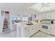 Bright, white kitchen with stainless steel appliances, a breakfast bar, and views of the ocean and living area at 7554 Palm Island S Dr # 1822, Placida, FL 33946