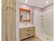 Bright bathroom featuring a wooden framed mirror, updated vanity, and walk-in shower at 842 E 6Th St, Englewood, FL 34223
