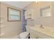 Bathroom featuring a shower, toilet, cabinet, and sink, all well-lit by natural light at 842 E 6Th St, Englewood, FL 34223