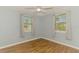 Cozy bedroom with light blue walls, wood floor and two large windows offering ample natural light at 842 E 6Th St, Englewood, FL 34223