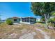 Exterior showcasing a cozy home with a screened lanai, a lush yard, and convenient canal access at 842 E 6Th St, Englewood, FL 34223
