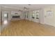 Spacious living room featuring wood floors, a modern fireplace, ceiling fans, and a decorative glass front door at 842 E 6Th St, Englewood, FL 34223