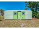 Exterior of a well-maintained shed featuring a door and windows in a green and neutral scheme at 842 E 6Th St, Englewood, FL 34223