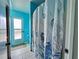 Shower with decorative seashell curtain in a bright blue tiled bathroom at 8472 Grand Ave, Placida, FL 33946