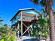 Beautiful coastal home on stilts with an inviting covered porch at 8472 Grand Ave, Placida, FL 33946