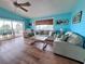 A large window lets in natural light to this living room which features hardwood floors and comfortable seating at 8472 Grand Ave, Placida, FL 33946