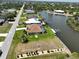 Waterfront home featuring a well-maintained lawn, mature landscaping, and easy access to the canal and waterways at 9158 Melody Cir, Port Charlotte, FL 33981