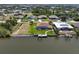 Aerial view showcasing a waterfront home with a screened-in pool area and a private boat dock on the canal at 9158 Melody Cir, Port Charlotte, FL 33981