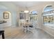 Bright dining area featuring wood-look tile floors, decorative windows, and views of the backyard pool area at 9158 Melody Cir, Port Charlotte, FL 33981