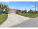 Large driveway leads to a beautiful home with well-maintained landscaping and mature palm trees at 9158 Melody Cir, Port Charlotte, FL 33981