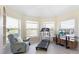 Sunlit exercise room with treadmill, cozy seating, and tranquil backyard views at 9158 Melody Cir, Port Charlotte, FL 33981