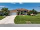 Charming home features a well-kept lawn, double-car garage, and beautiful palms at 9158 Melody Cir, Port Charlotte, FL 33981