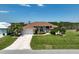Beautiful front yard with well-kept lawn, palm trees, and a circular driveway leading to the attached garage at 9158 Melody Cir, Port Charlotte, FL 33981