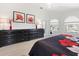 Well-lit main bedroom with tile floors, two dressers, and backyard views through the large windows at 9158 Melody Cir, Port Charlotte, FL 33981