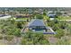 This aerial view shows the home and pool with a screened lanai, and backyard with white fencing at 9283 Newnan Cir, Port Charlotte, FL 33981