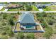 This aerial view shows the home and pool with a screened lanai, and backyard with white fencing at 9283 Newnan Cir, Port Charlotte, FL 33981