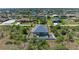 This aerial view shows the home and pool with a screened lanai, and backyard with white fencing at 9283 Newnan Cir, Port Charlotte, FL 33981