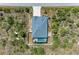 An aerial view shows the home, yard, lanai, pool and surrounding wooded space at 9283 Newnan Cir, Port Charlotte, FL 33981