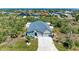 Aerial view of a well-maintained home with a spacious driveway and lush green lawn at 9283 Newnan Cir, Port Charlotte, FL 33981