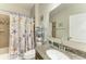 Bathroom featuring tub with shower, granite counters, and neutral-colored walls at 9283 Newnan Cir, Port Charlotte, FL 33981