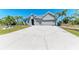 Spacious home boasting a manicured lawn, mature trees, and a large driveway at 9283 Newnan Cir, Port Charlotte, FL 33981