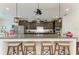 Modern kitchen featuring granite countertops, dark cabinets, stainless appliances, and bar seating at 9283 Newnan Cir, Port Charlotte, FL 33981